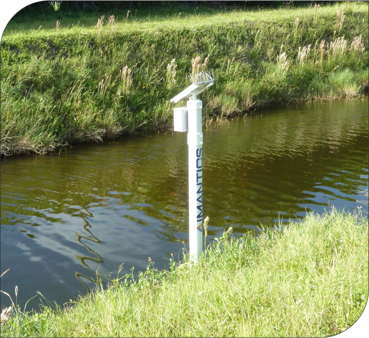 Imantics HydroView sensor package: a solar-powered monitoring station installed at the edge of a drainage channel.